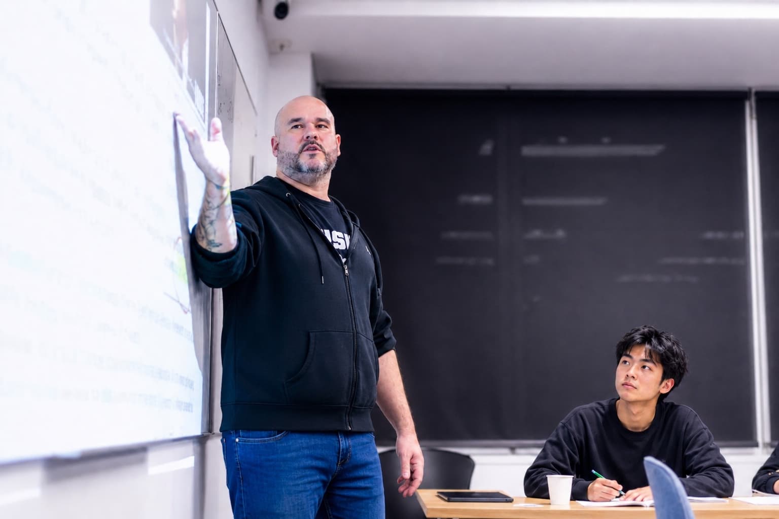 A Sigma Science teacher working through a physics problem at the board